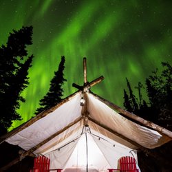 Alpenglow Luxury Camping - The northern lights dancing over one of Alpenglow's Luxury tents in late season. Photo by David Crane