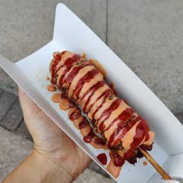 Squid ink corndog with honey butter powder, spicy mayo and ketchup Squid ink corndog with honey butter powder, spicy mayo and ketchup