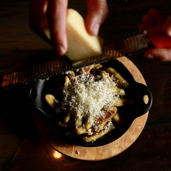 The Fountain Inn - a person grating cheese over pasta in a cast iron skillet - Cocktail Bars Near Me - Washington, DC, District of Columbia The Fountain Inn - a person grating cheese over pasta in a cast iron skillet - Cocktail Bars Near Me - Washington, DC, District of Columbia