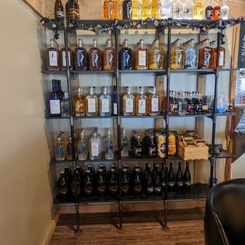 Spirit Water - a shelf of liquor bottles and liquor glasses - Breweries Near Me - Cary, Illinois