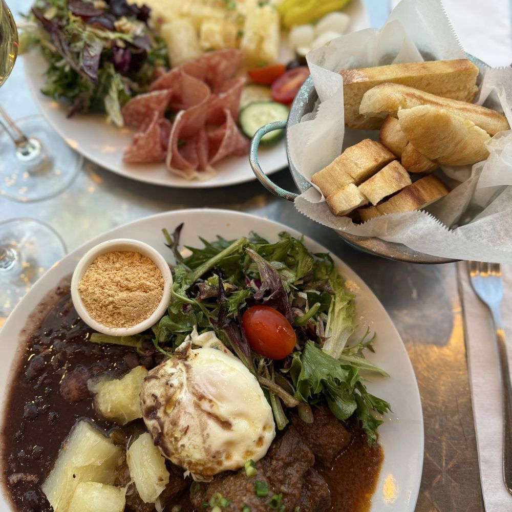 Top plate: raclette, salami, prosciutto and salad. Bottom: beef stew, yucca, rice, black bean and salad Top plate: raclette, salami, prosciutto and salad. Bottom: beef stew, yucca, rice, black bean and salad