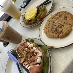 Chai latte with oat milk, Whipped Ricotta Toast (w/ Prosciutto), salted caramel cookie, Sunrise Avocado Toast and a frozen lemonade.
