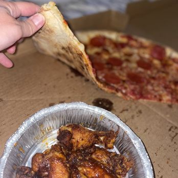 Mr. Maines Pizzeria - a hand holding a piece of pizza - Pizza Near Me - Panama City Beach, Florida Mr. Maines Pizzeria - a hand holding a piece of pizza - Pizza Near Me - Panama City Beach, Florida