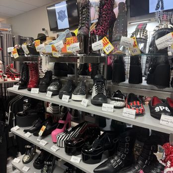 Freak House - A retail store shelf showcases women's footwear, including boots, sneakers, and high heels, with sale tags and price labels. - Shoe Stores Near Me - Miami, Florida