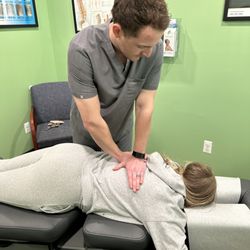Clarkston Chiropractic Sports & Wellness - Dr. Matthew Wray performing a chiropractic adjustment on middle back.