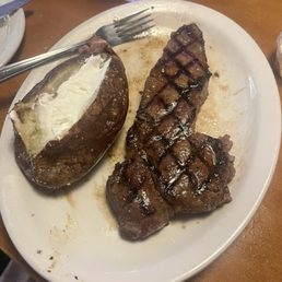 Hand cut New York strip steak and baked potato. Hand cut New York strip steak and baked potato.