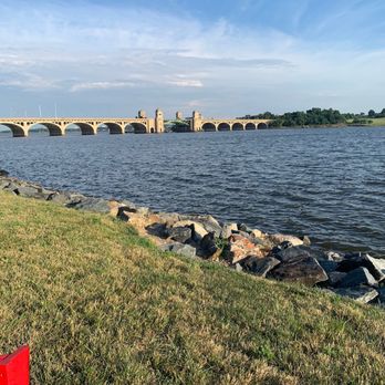 South Point - Port Covington - a red fire hydrant in the foreground and a bridge in the background - Tiki Bars Near Me - Baltimore, Maryland South Point - Port Covington - a red fire hydrant in the foreground and a bridge in the background - Tiki Bars Near Me - Baltimore, Maryland