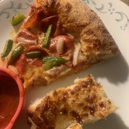 a slice of pizza and a small bowl of sauce