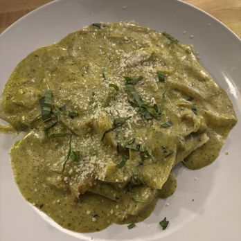 M’tucci’s Bar Roma - Artichoke Ravioli Giardino - Artichoke ravioli covered in a green sauce, topped with grated cheese and chopped herbs, served on a white plate. - Cocktail Bars Near Me - Albuquerque, New Mexico