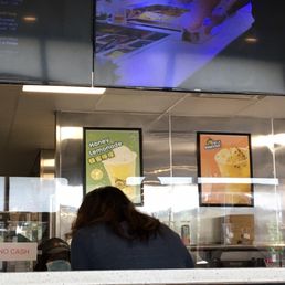 a woman sitting at a counter in a fast food restaurant