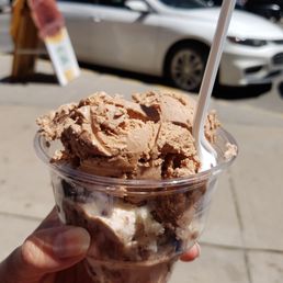 a hand holding a cup of ice cream