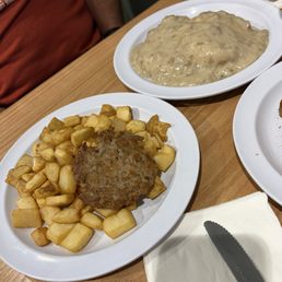 Three side items. Biscuits and gravy, home fries and sausage.