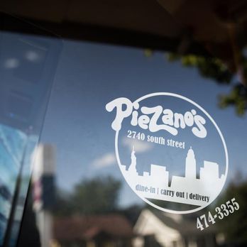 Piezano's - the reflection of a building in the window - Pizza Near Me - Lincoln, Nebraska