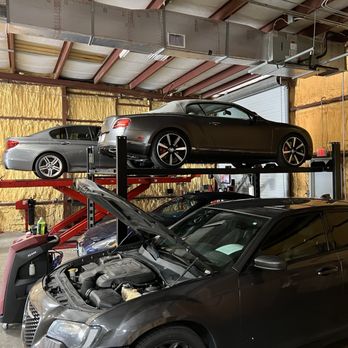 Exklusiv European Service - Chrysler being worked on Bentley and BMW on Storage racks - Auto Repair Near Me - Naples, Florida