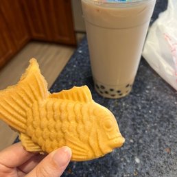 a person holding a fish shaped cookie