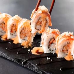Rock N Roll Sushi - Cajun-seasoned crawfish inside, krab stick outside, topped with spicy mayo, eel sauce and crunchy flakes.