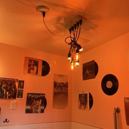 a bathroom with a light fixture and pictures on the wall a bathroom with a light fixture and pictures on the wall