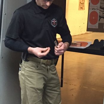 Lead Through The Cross Safety - Chris gets a magazine ready for his next student. - Firearm Training Near Me - Rockville, Maryland Lead Through The Cross Safety - Chris gets a magazine ready for his next student. - Firearm Training Near Me - Rockville, Maryland