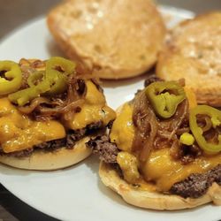 Smash N' Sizzle - Caramelized onions and jalapenos on top of warm toasty brioche buns with our double patty (Two to tango) smashburger!