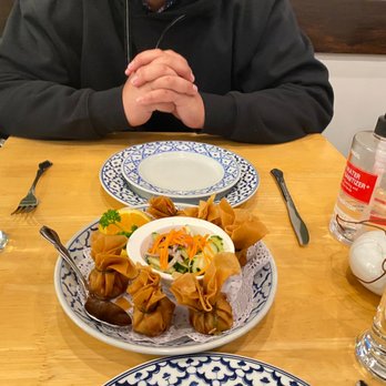 Regent Thai Restaurant - a man sitting at a table with plates of food - Thai Near Me - San Francisco, California Regent Thai Restaurant - a man sitting at a table with plates of food - Thai Near Me - San Francisco, California