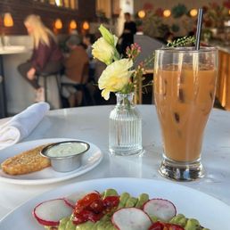 Avocado toast, hash brown, and an iced latte.