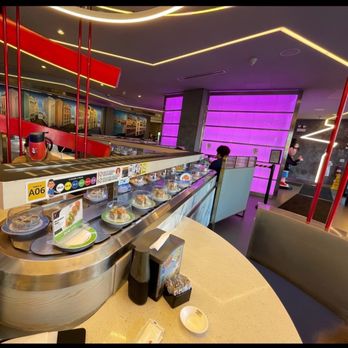Sushi Plus Rotary Sushi Bar - The rotary belt and some art decorating the back wall. That purple wall changes color avery few minutes. - Sushi Bars Near Me - Chicago, Illinois Sushi Plus Rotary Sushi Bar - The rotary belt and some art decorating the back wall. That purple wall changes color avery few minutes. - Sushi Bars Near Me - Chicago, Illinois