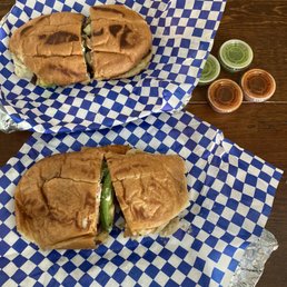 two sandwiches on blue and white checkered paper two sandwiches on blue and white checkered paper