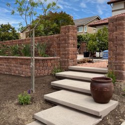 RND’s Tree and Landscaping Service - Custom concrete floating steps leading to a locking block retaining wall and raised planting area.