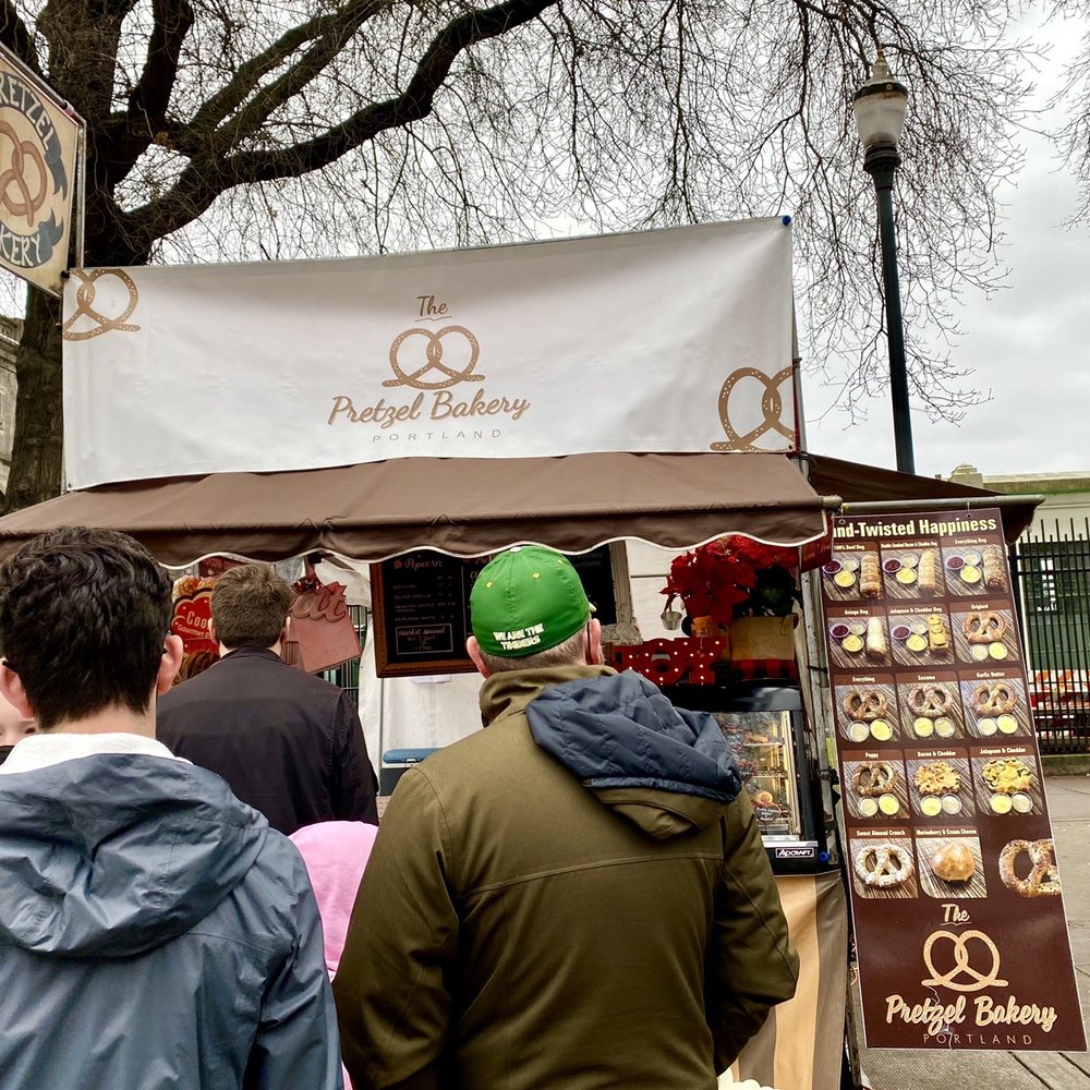 The Pretzel Bakery - people standing in front of a food stand - Pretzels Near Me - Portland, Oregon The Pretzel Bakery - people standing in front of a food stand - Pretzels Near Me - Portland, Oregon