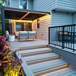 Vandeck Builders - Close-up of contemporary deck in Bayside, highlighting LED step lighting and a vibrant flower bed, designed by Vandeck Builders.