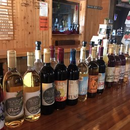 a variety of wines lined up on a bar a variety of wines lined up on a bar