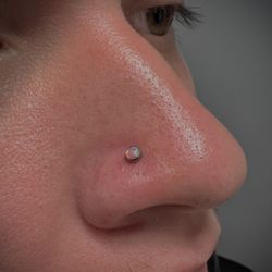 Essential Ink Body Art - Nostril piercing with pink opal.