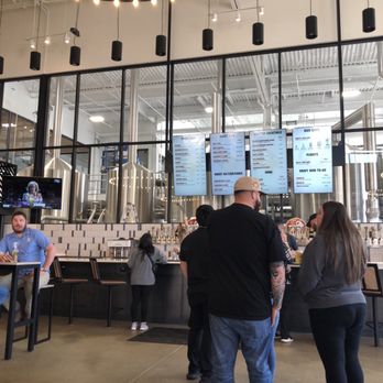 Prost Brewing - This is a picture of the bar and their menus with their brewing equipment behind the glass. - Breweries Near Me - Northglenn, Colorado Prost Brewing - This is a picture of the bar and their menus with their brewing equipment behind the glass. - Breweries Near Me - Northglenn, Colorado