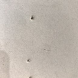 Screw holes in drywall - no anchors.