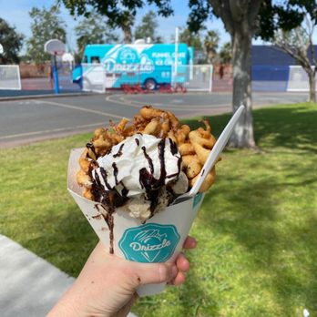 Drizzle - a hand holding a cup of ice cream and waffles - Desserts Near Me Drizzle - a hand holding a cup of ice cream and waffles - Desserts Near Me