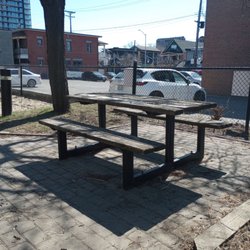 McCann Park - Picnic table. On the other side of the fence is a bank and the bank's parking lot.