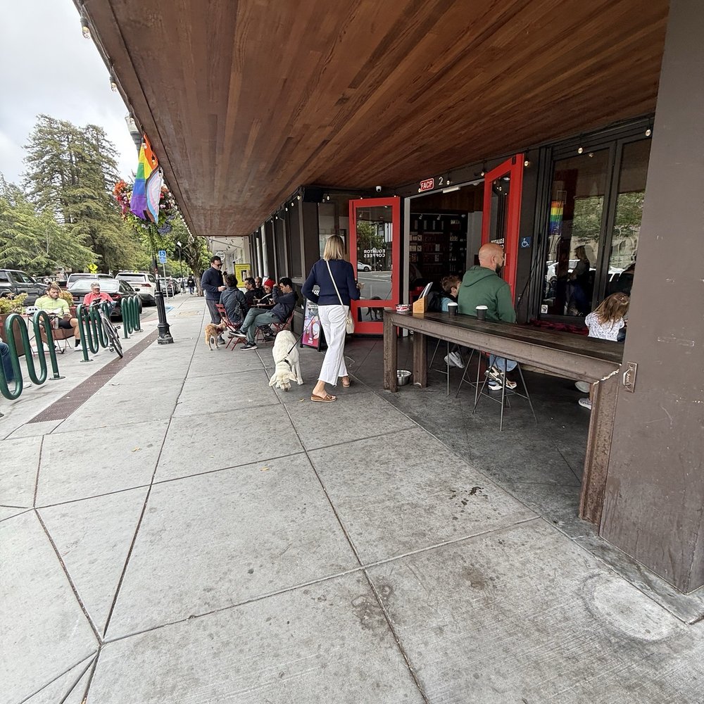 Equator Coffees - Visitors perch at bench to watch corner traffic breeze through. Note plenitude of bicycle parking on left. Red doors indicate entrance. - Coffee & Tea Near Me - Mill Valley, California Equator Coffees - Visitors perch at bench to watch corner traffic breeze through. Note plenitude of bicycle parking on left. Red doors indicate entrance. - Coffee & Tea Near Me - Mill Valley, California