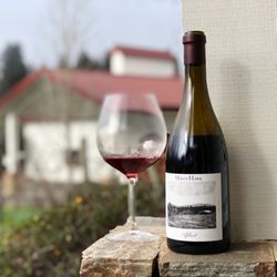 Maggy Hawk - A bottle of our Afleet Pinot Noir with our winery in the background.