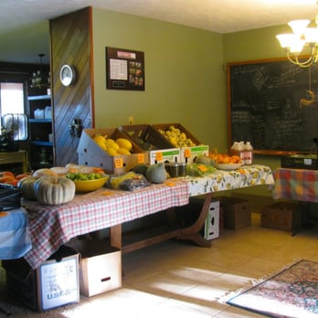 Sleeping Frog Farms - a man standing in front of a fruit stand - Farmers Market Near Me - Benson, Arizona