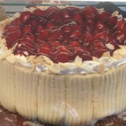 Ok Pasteleria - Un rico pastel de tres leches con una cubierta de fresas.