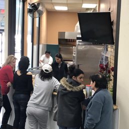 a group of people standing around a counter a group of people standing around a counter