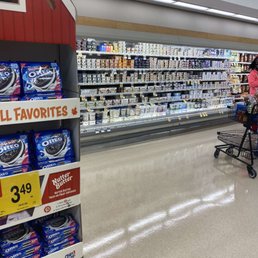 a woman pushing a shopping cart in a grocery store a woman pushing a shopping cart in a grocery store