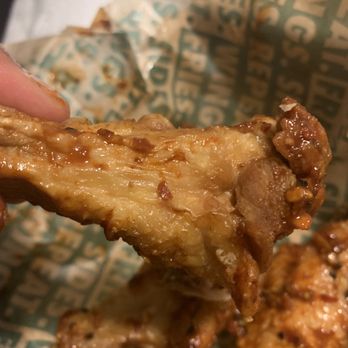 Wingstop - a hand holding a piece of fried chicken - Chicken Wings Near Me - Coachella, California Wingstop - a hand holding a piece of fried chicken - Chicken Wings Near Me - Coachella, California