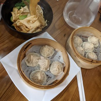 Chinese Traditional Buns - a wooden table with bowls of dumplings - Chinese Near Me - Toronto, Ontario