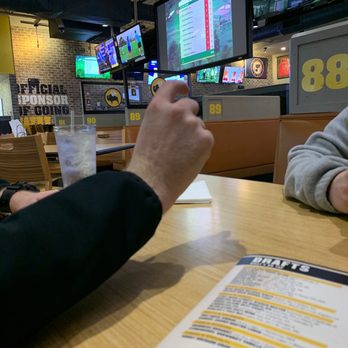 Buffalo Wild Wings - two men sitting at a table with a menu in front of them - Chicken Wings Near Me - O'Fallon, Illinois Buffalo Wild Wings - two men sitting at a table with a menu in front of them - Chicken Wings Near Me - O'Fallon, Illinois