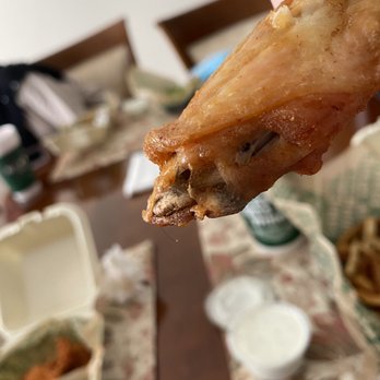 Wingstop - a hand holding a piece of food - Chicken Wings Near Me - Burlington, North Carolina