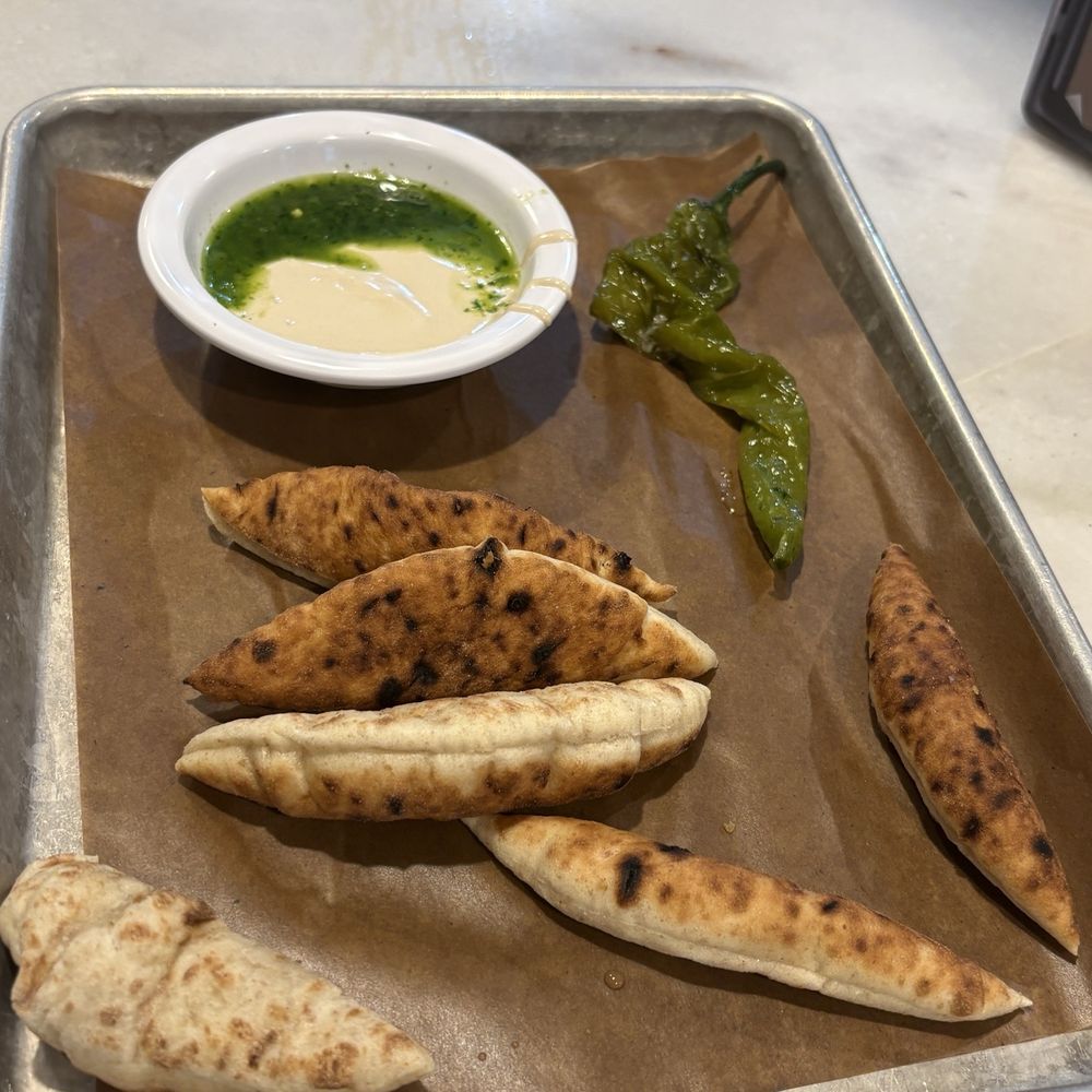 Miznon Kosher - Pita pieces with tahini and chug - Mediterranean Near Me - New York, New York Miznon Kosher - Pita pieces with tahini and chug - Mediterranean Near Me - New York, New York