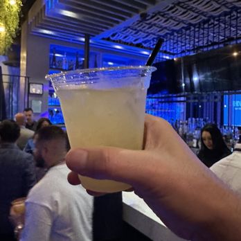 Downtown Experiment - a person holding a drink at a bar - Bars Near Me - Riverside, California Downtown Experiment - a person holding a drink at a bar - Bars Near Me - Riverside, California