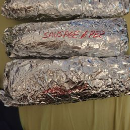 three wrapped sandwiches on a plate three wrapped sandwiches on a plate