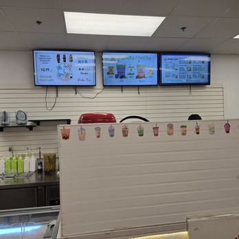 Momo Cafe - Three digital screens display the menu at Momo Cafe, a bubble tea shop in Schaumburg, IL, with drink options and prices. - Cafes Near Me - Schaumburg, Illinois